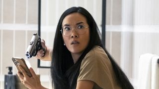 Ali Wong as Amy, pointing a gun at an iPhone in episode 102 of Beef