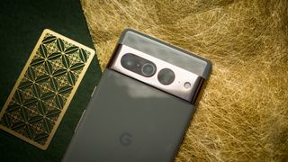 Google Pixel 7 Pro back view showcasing camera bar against gold background