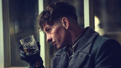 Barry Keoghan tips a whiskey glass towards a window