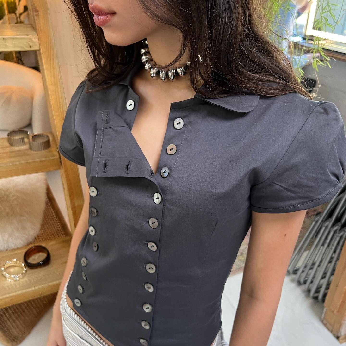 Woman wearing shirt with mother-of-pearl buttons.