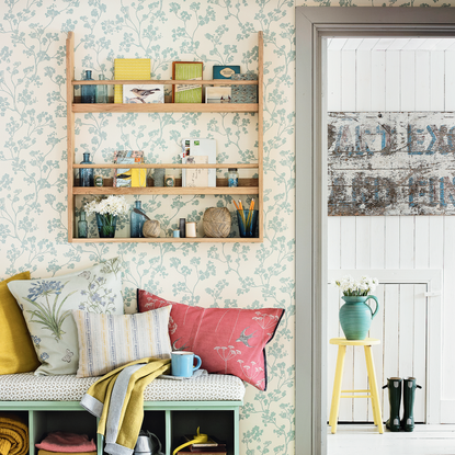 room with wallpaper on wall and cushions