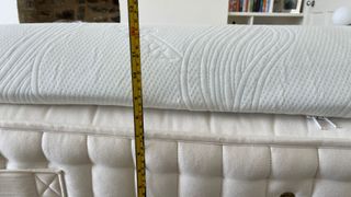 A tape measure showing the depth of the TheraPur ActiGel Cool Mattress Topper