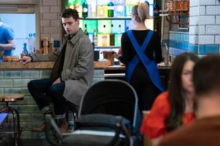 Johnhy Carter is in Walford East restaurant and he looks towards the Slater and Branning family lunch