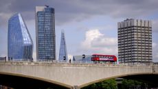 a Go-Ahead bus driving over Waterloo Bridge with skyscrapers in the background