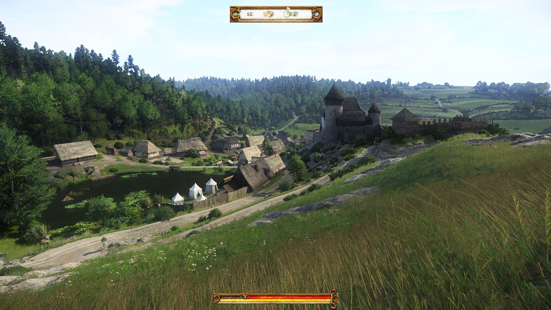 Kingdom Come: Deliverance - A small medieval village on a dirt road beneath a grassy hill