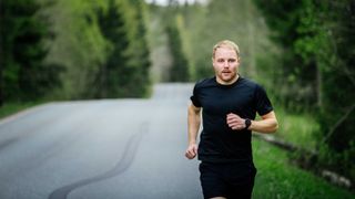F1 driver runninf in a foresty area wearing the Polar Vantage V2