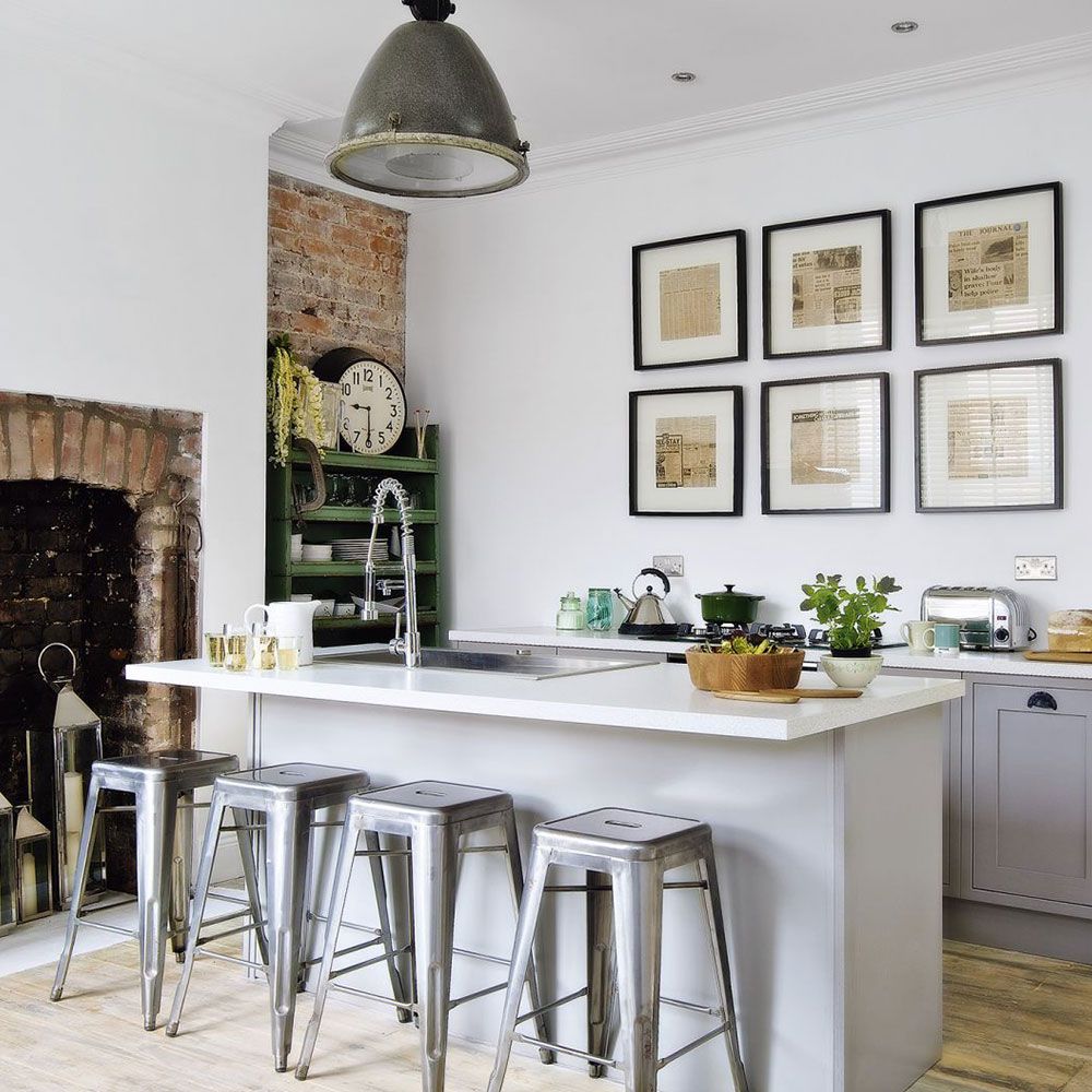 kitchen area with white wall and white kitchen units and picture frames