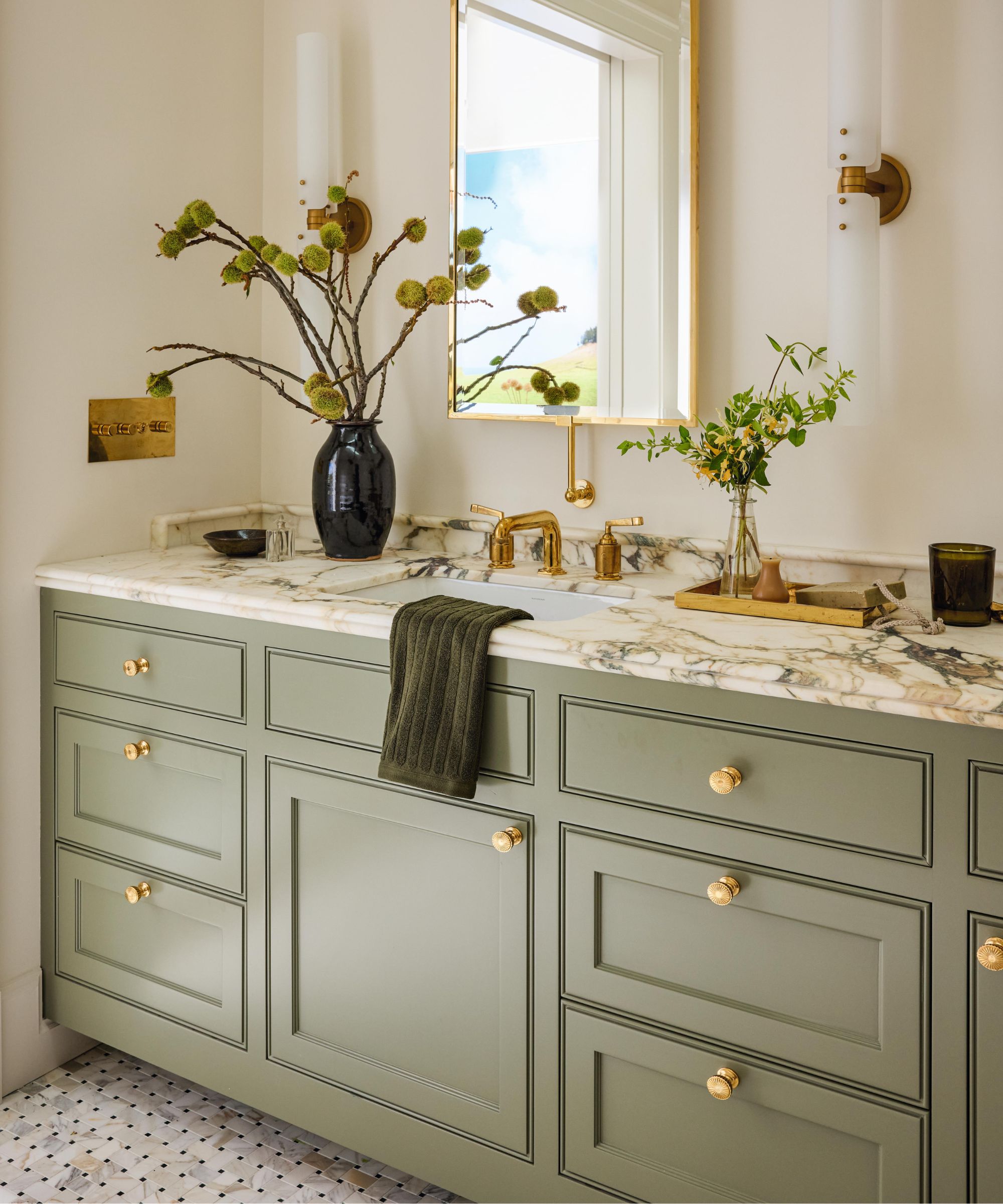 a main bathroom with sage green vanity and veined marble