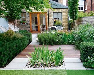Narrow garden with decking, fence and lawn