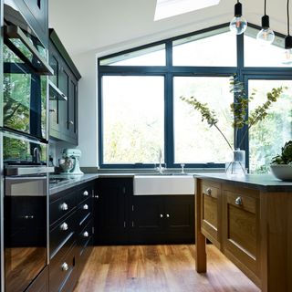 kitchen with black glossy wall unit and timber flooring