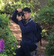 Eric Hsu taking a photograph in a garden