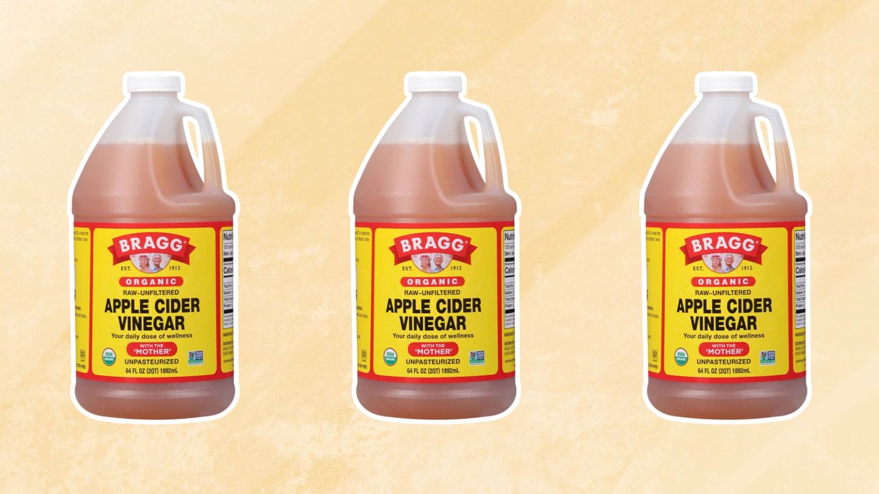 Three bottles of apple cider vinegar on yellow background