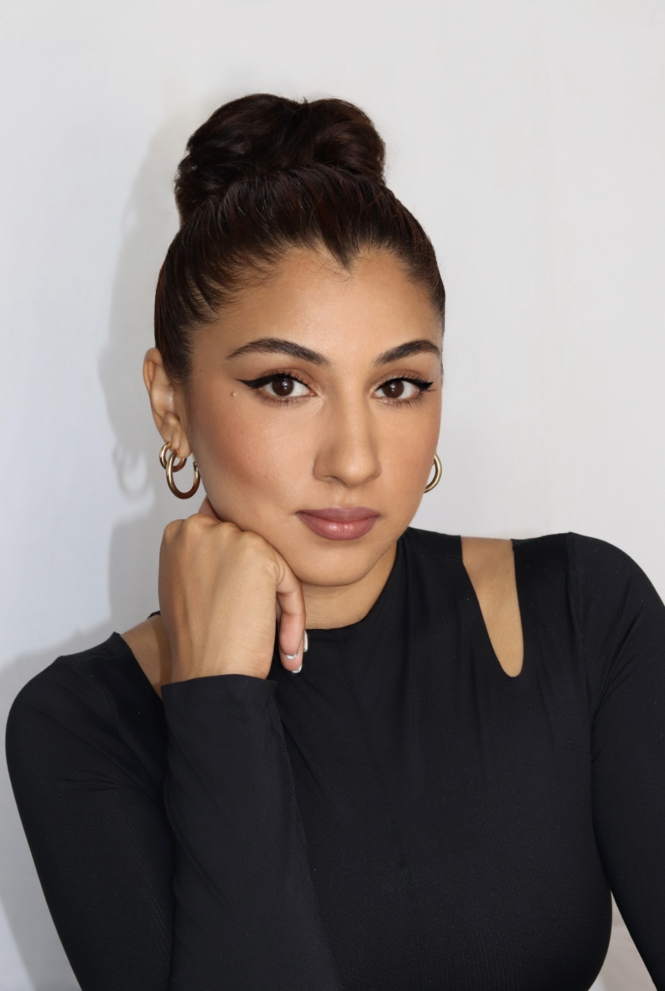 a brown woman with a black updo in a black turtleneck