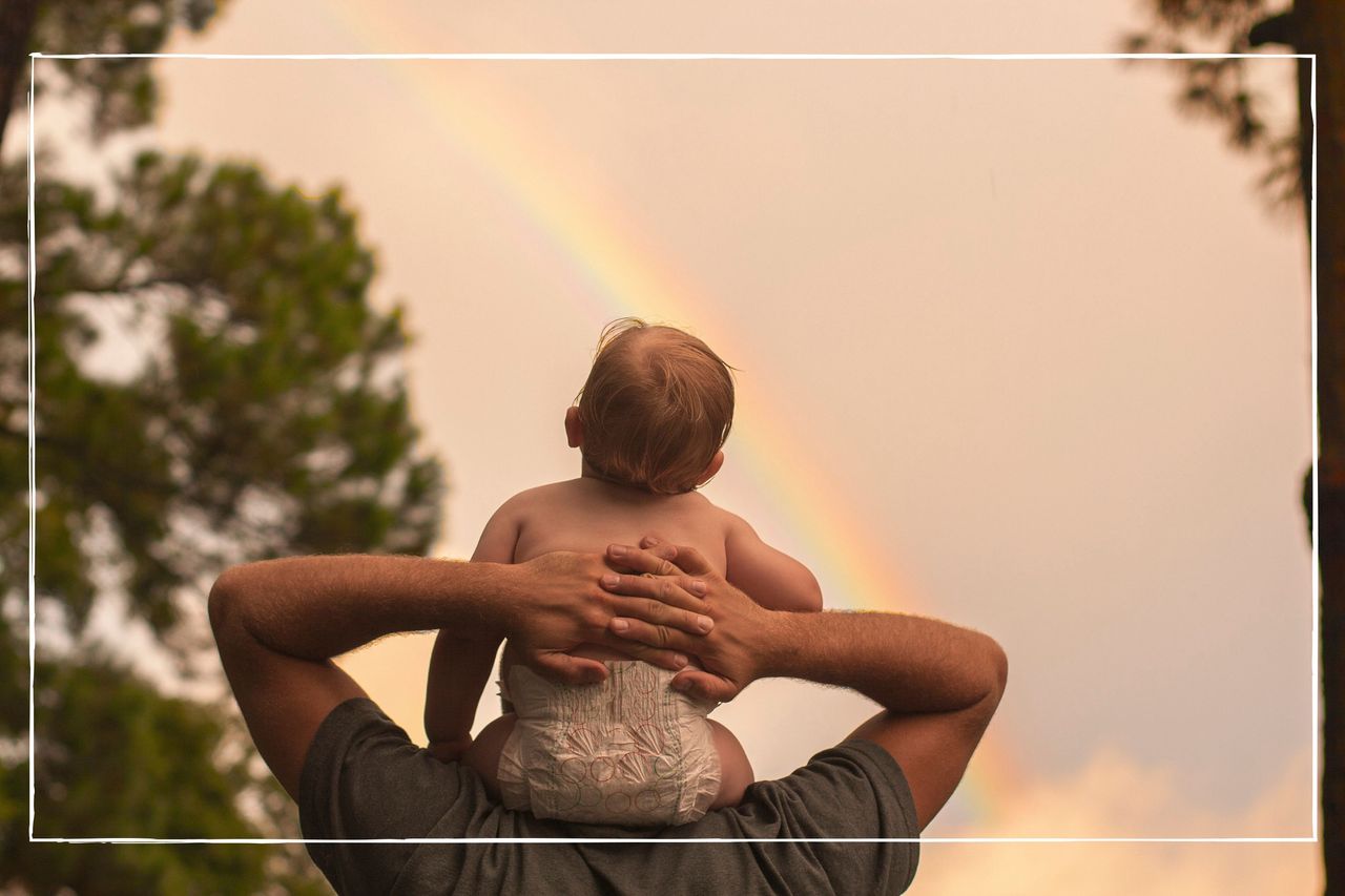 Rainbow baby ilustrated by Baby on grown up shoulders under a rainbow outside