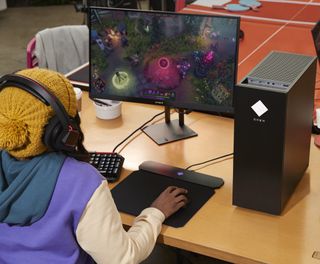 A gamer playing on an HP Omen 30L.
