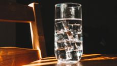 Water glass on a table with light filtering through