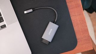 Anker PowerExpand+ 2-in-1 SD 4.0 Card Reader on a black leather mat