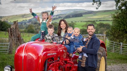 Kelvin fletcher and family on a red tractor in a field