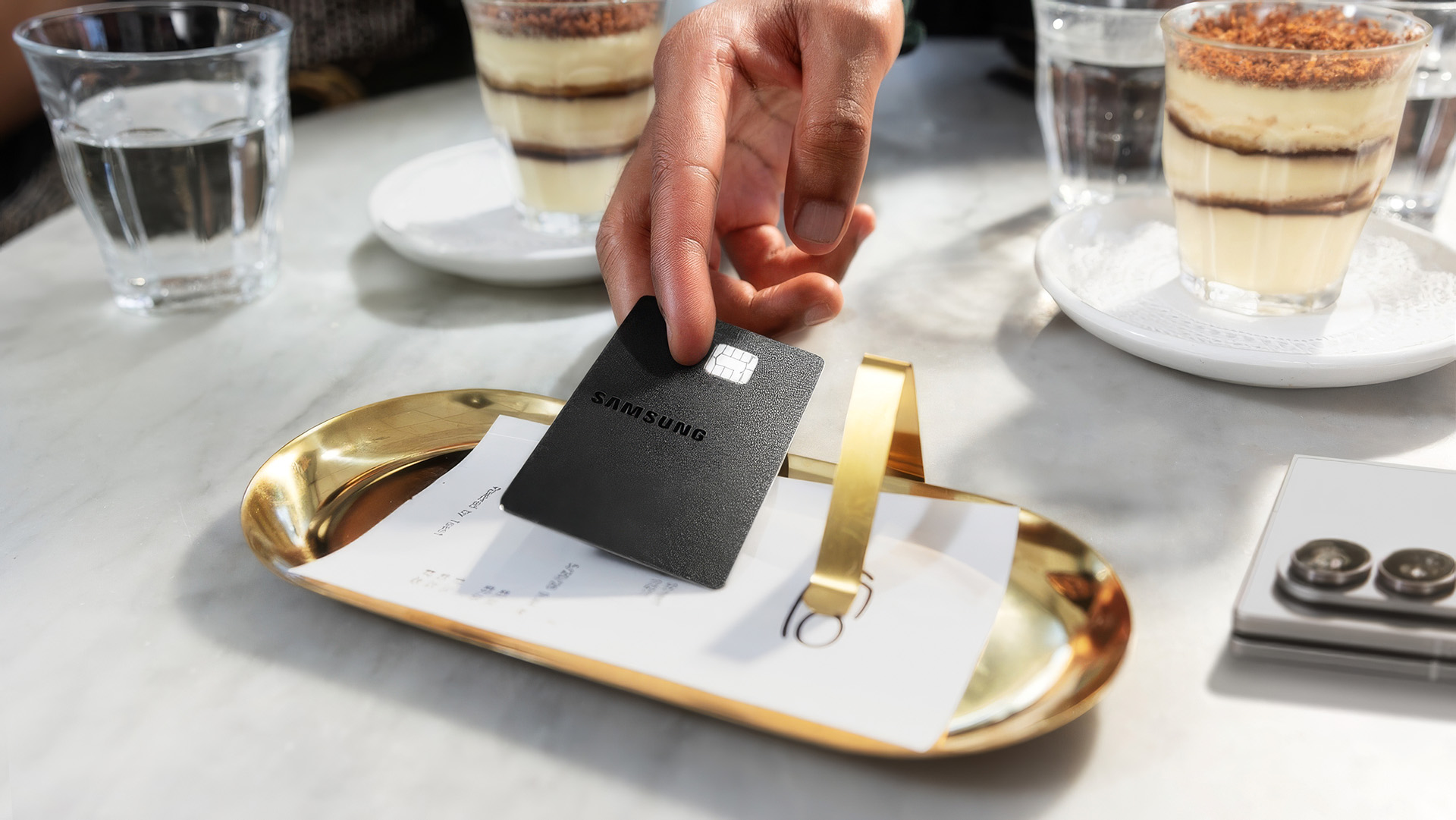 Samsung Galaxy Credit Card being used to pay a bill at a restaurant