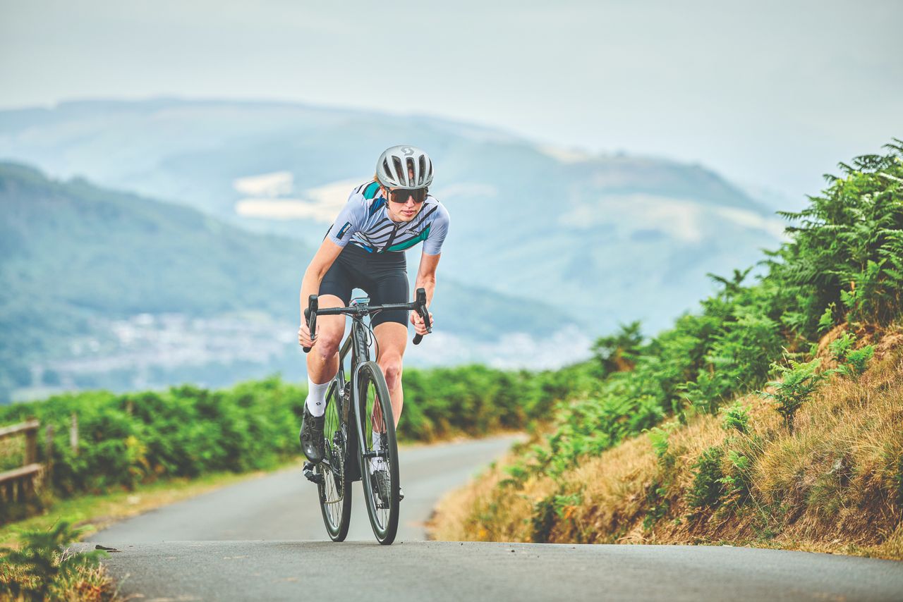 Female cyclist climbs in summer kit