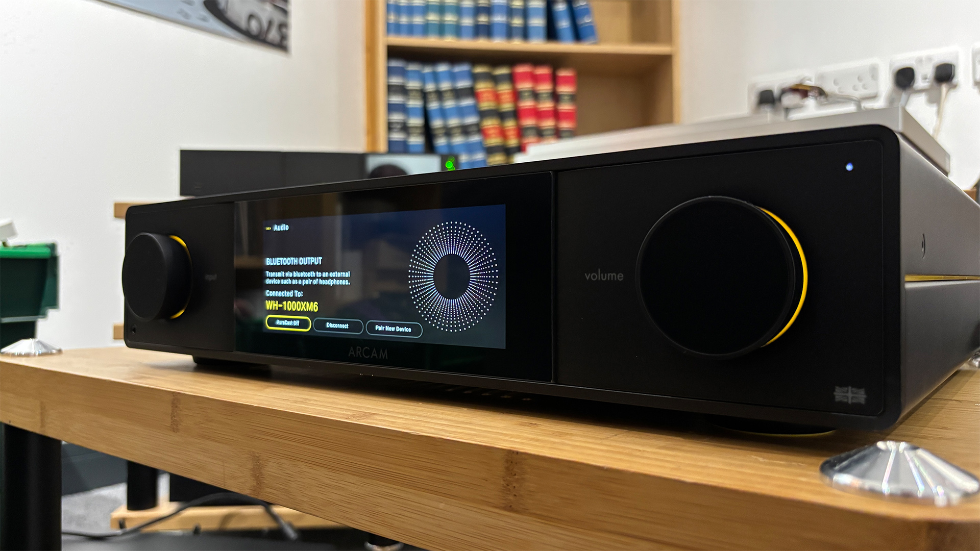 Arcam SA35 music streamer on wooden rack with Bluetooth headphones connected on display