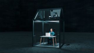 A CGI render of a businessman sitting at a desk in a tiny glass house, surrounded by darkness, to represent remote working risks.