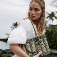 Woman wearing white dress and handbag from Bergdorf Goodman