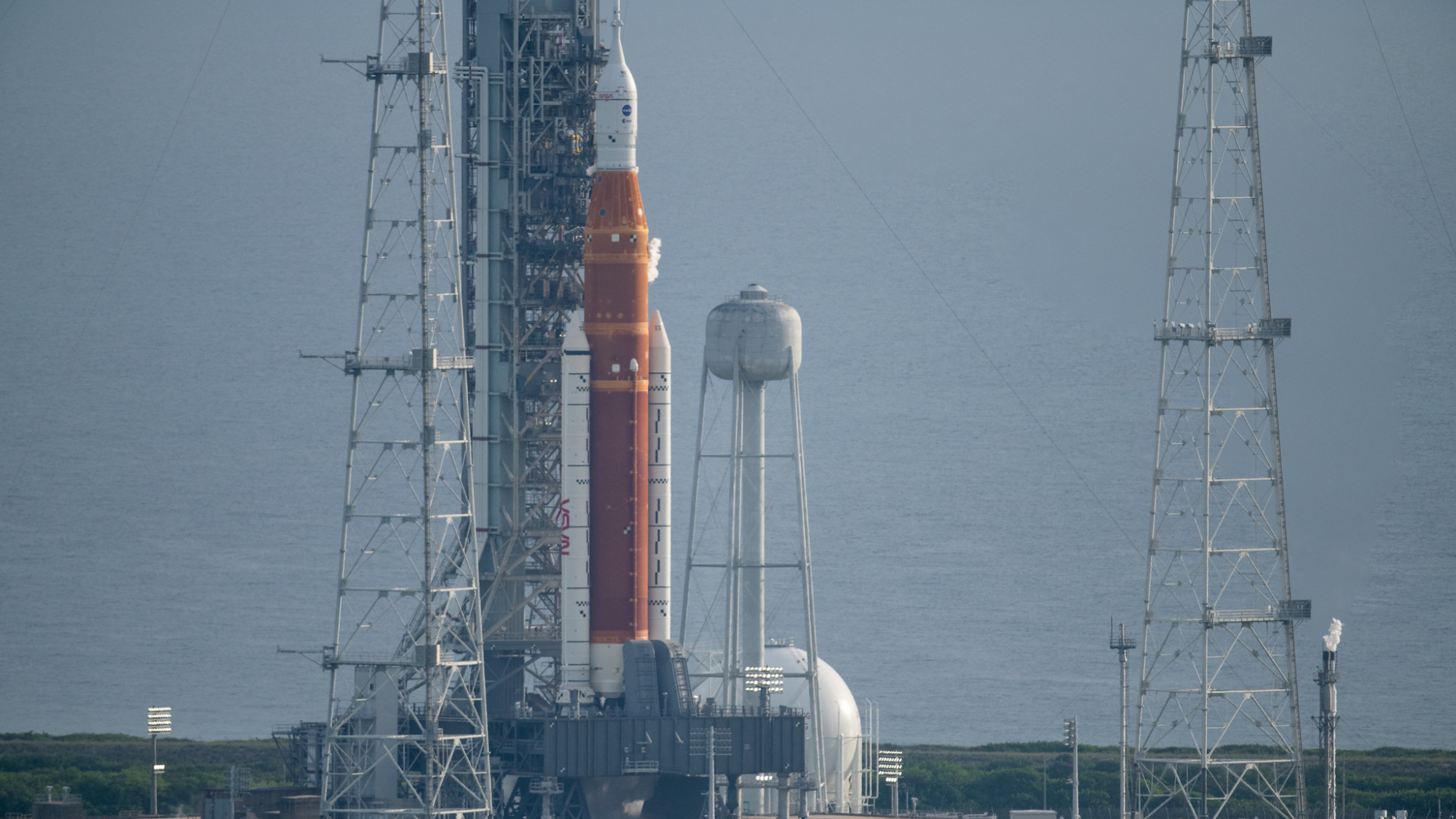 giant space launch system on the launch pad with ocean behind