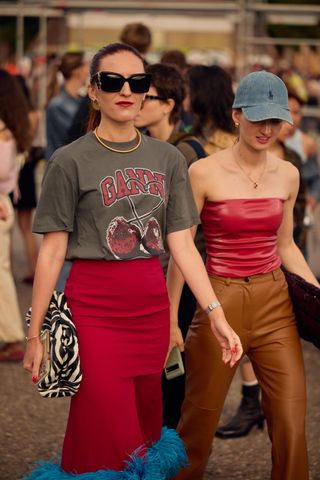 Woman in graphic tee and red skirt.