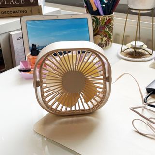 Small neutral desk fan on table