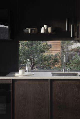 view of kitchen designed by vipp, black fittings and white counter with sink