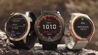 Three Garmin Fenix 7 watches sitting on a rock