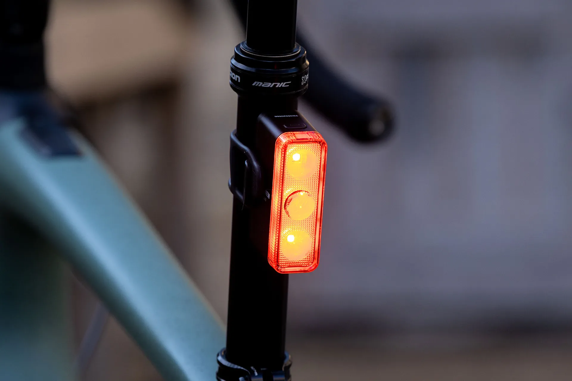 The Ravemen TR500 smart rear bike light, a rectangular shaped rear light and 3 vertically stacked LEDs mounted to the seatpost of a Specialized Turbo Creo