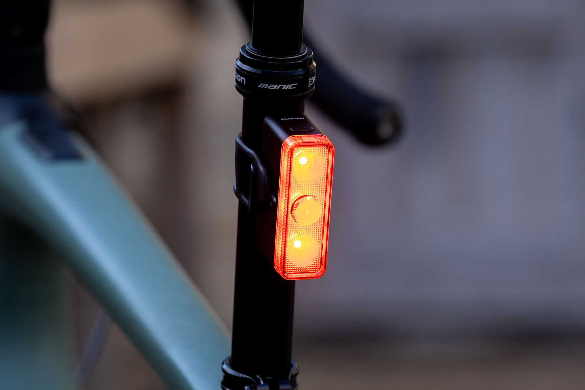 The Ravemen TR500 smart rear bike light, a rectangular shaped rear light and 3 vertically stacked LEDs mounted to the seatpost of a Specialized Turbo Creo
