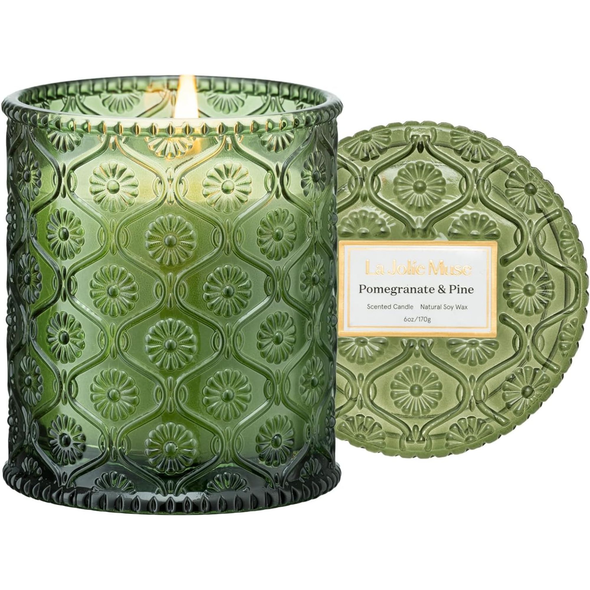 Lit pomegranate &amp;amp; pine candle in a green glass vessel