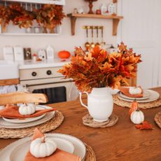 Holiday table in kitchen with leaves and pumpkins