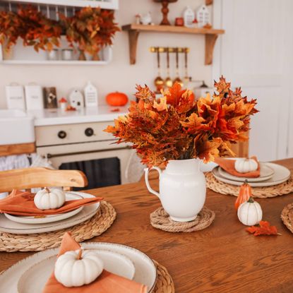 Holiday table in kitchen with leaves and pumpkins