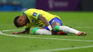 内马尔在卡塔尔世界杯巴西对阵塞尔维亚的比赛中受伤，他抱着脚踝。