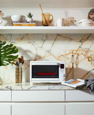 ‘Aln1’ toaster oven. A white square toaster oven on a white marble kitchen coutner.