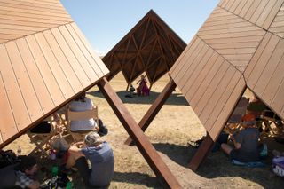 architectural canopies forming geodes, with audience and musicians underneath