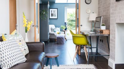 room with leather sofa set and desk with yellow chair