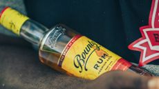 A bottle of Bounty Rum being held