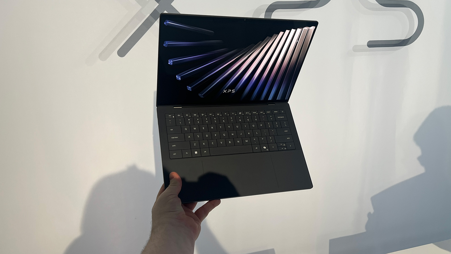 A Dell XPS 14 in a man's hand