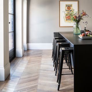 Kitchen with wooden chevron floor and black island