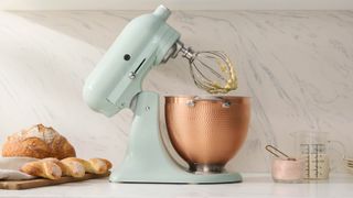 KitchenAid Blossom Stand Mixer on a countertop next to bread and ingredients