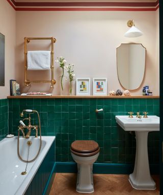 bathroom with green tiles painted border at top of wall