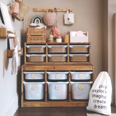 A light brown-painted playroom with the IKEA TROFAST storage system customised with labels and stickers
