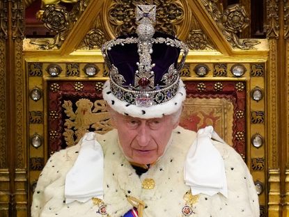 Britain's King Charles III, wearing the Imperial State Crown and the Robe of State, reads the King's speech from The Sovereign's Throne in the House of Lords chamber, during the State Opening of Parliament, at the Houses of Parliament, in London, on November 7, 2023