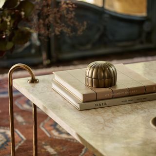 A small gold decorative object on a marble coffee table from Lulu and Georgia