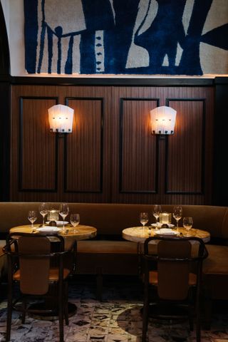 Wall lamps on dark-wood panelling at Locanda Verde Hudson Yards